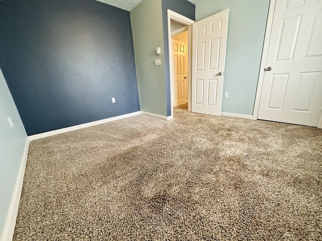 unfurnished bedroom featuring baseboards and carpet floors