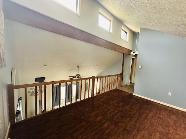 interior space featuring a ceiling fan, a textured ceiling, and wood finished floors