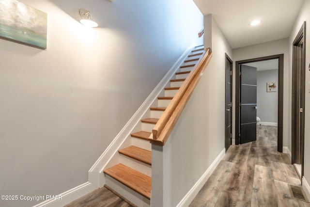 stairs featuring wood finished floors and baseboards