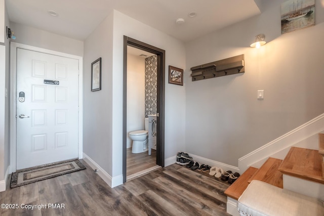 bathroom featuring toilet, baseboards, and wood finished floors