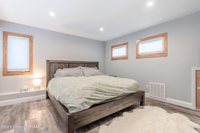 bedroom featuring visible vents, recessed lighting, baseboards, and wood finished floors