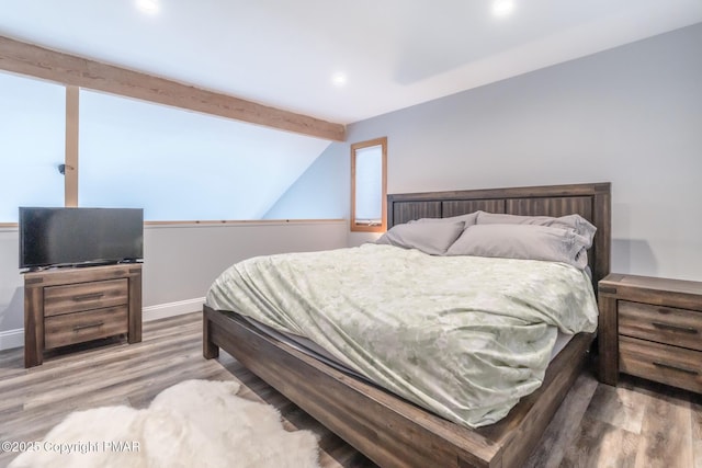 bedroom with beam ceiling and hardwood / wood-style floors