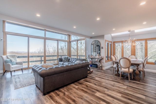 living area featuring a notable chandelier, recessed lighting, baseboards, and wood finished floors