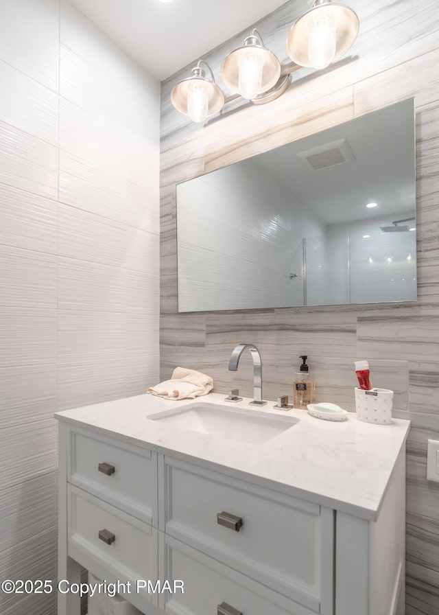 bathroom with tile walls and vanity