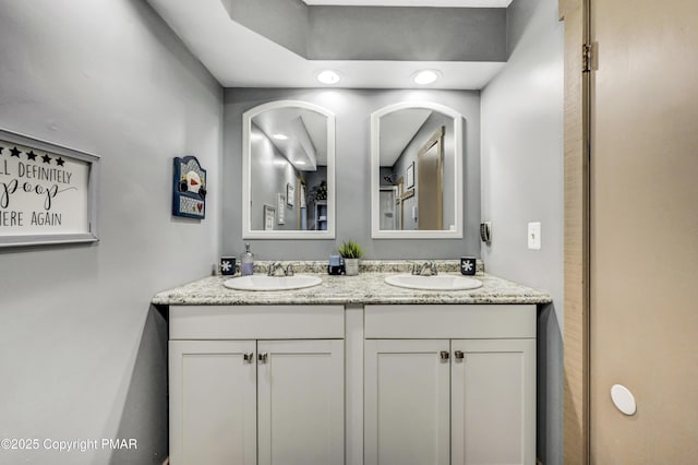 full bathroom with a sink and double vanity