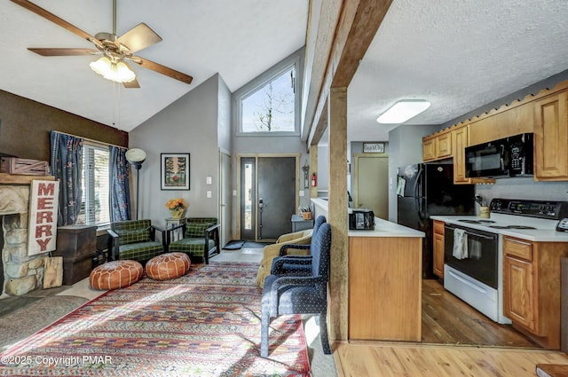 kitchen with a healthy amount of sunlight, black appliances, open floor plan, and light countertops