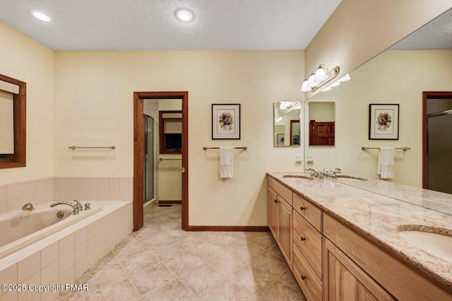 full bathroom with double vanity, a sink, a shower stall, and a bath