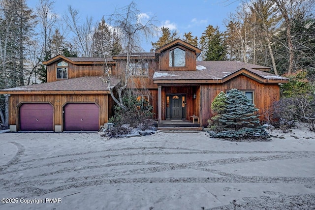 chalet / cabin featuring roof with shingles and an attached garage