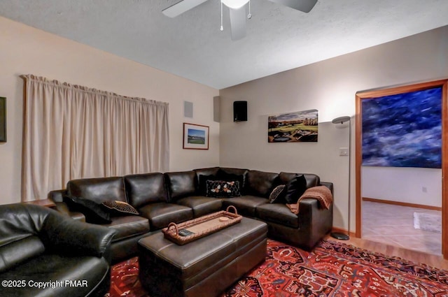 living room featuring visible vents, baseboards, a ceiling fan, lofted ceiling, and tile patterned flooring