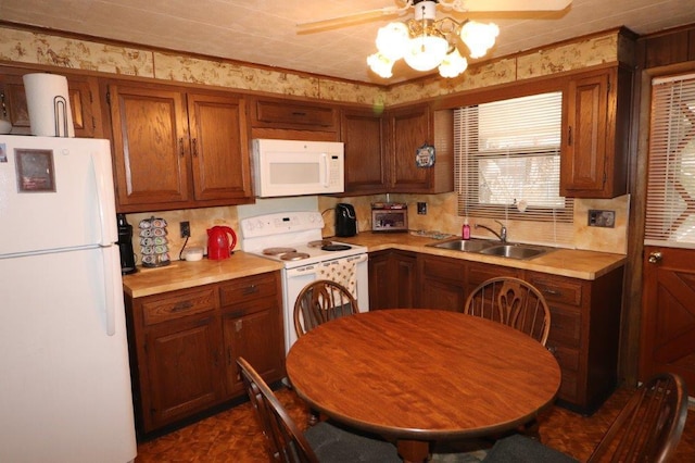 kitchen featuring white appliances, ceiling fan, brown cabinets, light countertops, and a sink