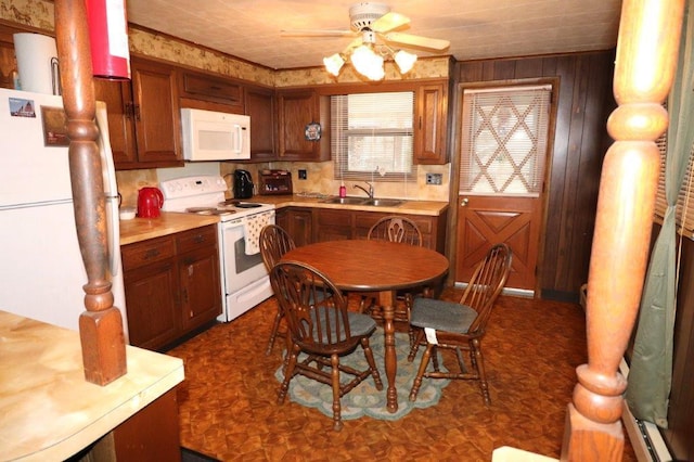 kitchen with brown cabinets, light countertops, a sink, ceiling fan, and white appliances