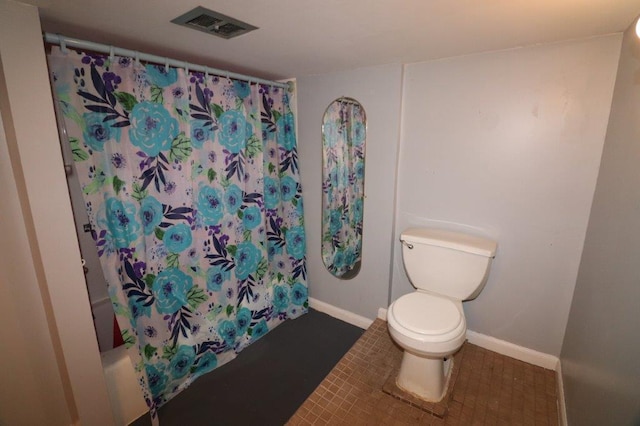 bathroom featuring toilet, baseboards, visible vents, and shower / bath combo with shower curtain