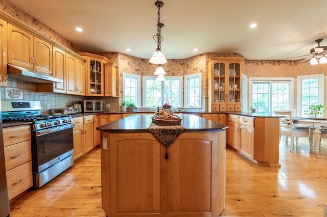 49 Central Dr, Easton, PA 18045 - kitchen featuring stainless steel range with gas cooktop, a kitchen island, under cabinet range hood, dark countertops, and wallpapered walls