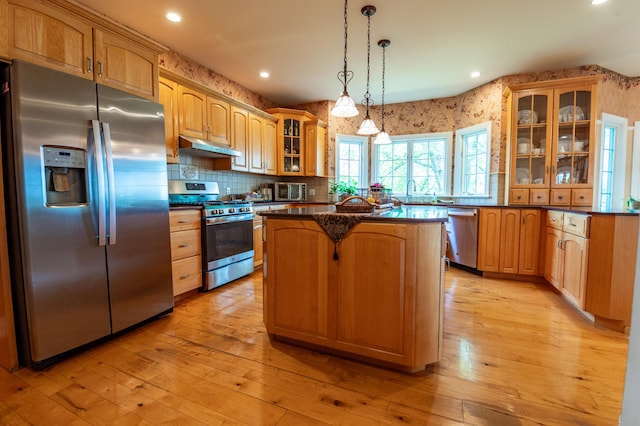 49 Central Dr, Easton, PA 18045 - kitchen featuring appliances with stainless steel finishes, wallpapered walls, a kitchen island, under cabinet range hood, and dark countertops