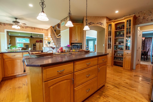 49 Central Dr, Easton, PA 18045 - kitchen featuring dark countertops, ceiling fan, glass insert cabinets, light wood-style flooring, and pendant lighting