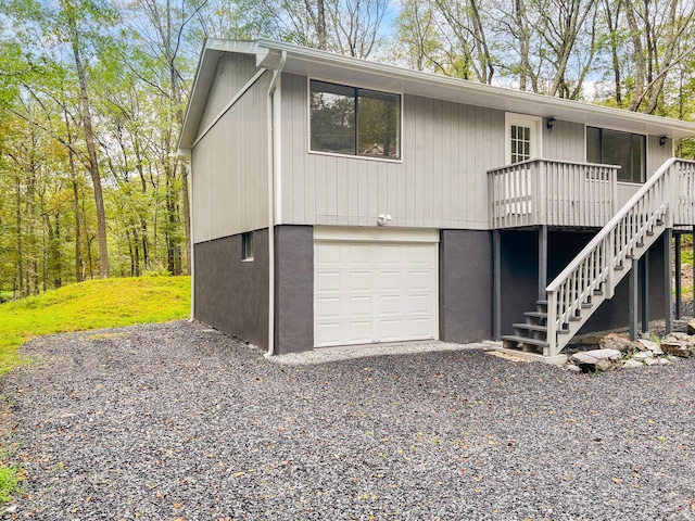 319 Whipporwill Dr, Bushkill, PA 18324 - view of front facade featuring stairs, a garage, a wooden deck, and driveway