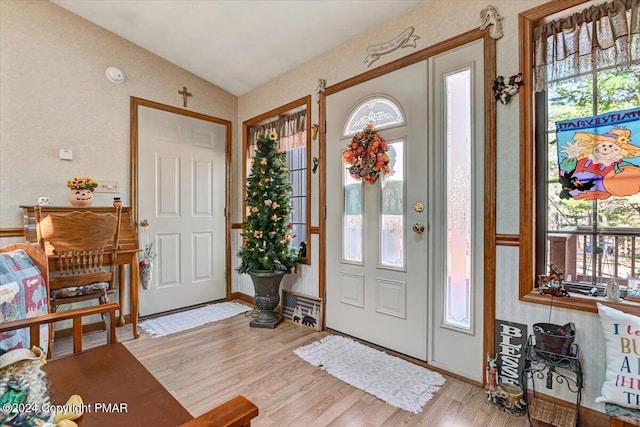 entryway featuring light wood-style floors and vaulted ceiling