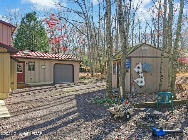 view of yard featuring a garage, an outbuilding, and driveway