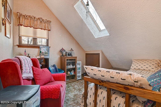 bedroom with carpet floors, vaulted ceiling with skylight, and a textured ceiling