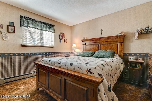 carpeted bedroom featuring a textured ceiling, baseboard heating, wainscoting, and wallpapered walls