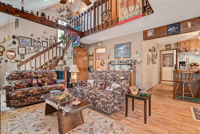 living room with stairs, wood finished floors, a ceiling fan, and baseboards