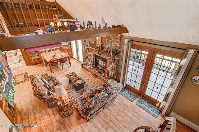 living room featuring a fireplace, wood finished floors, a ceiling fan, and baseboards