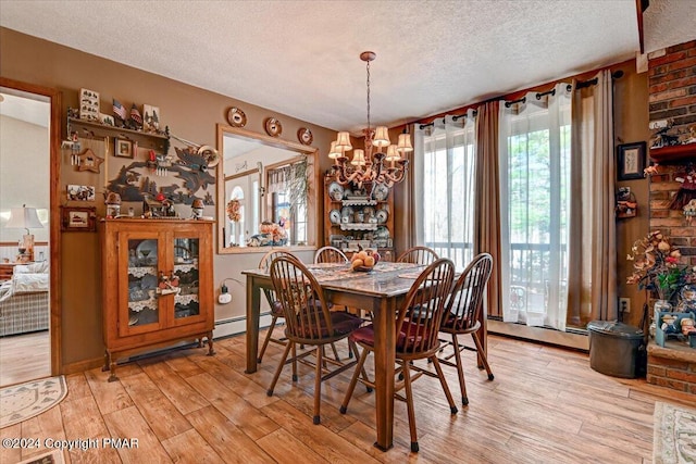 dining space featuring a chandelier, light wood-style flooring, baseboard heating, and a textured ceiling