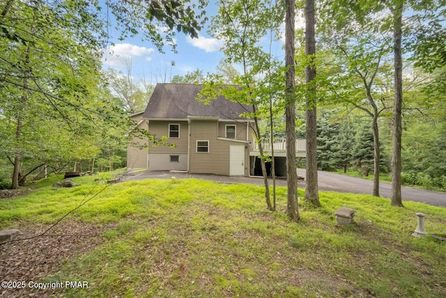 back of property with a wooden deck and a yard