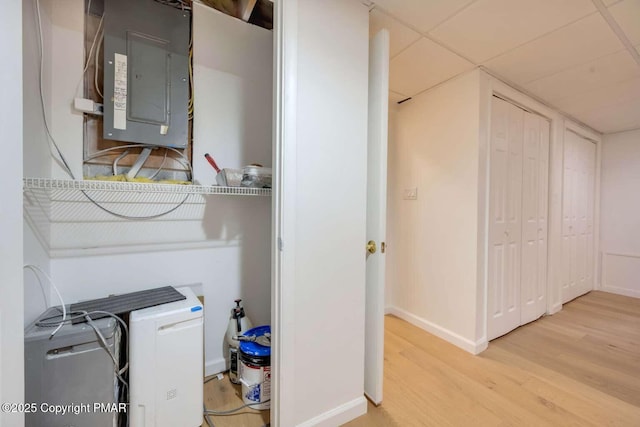 laundry area featuring electric panel and light wood-type flooring