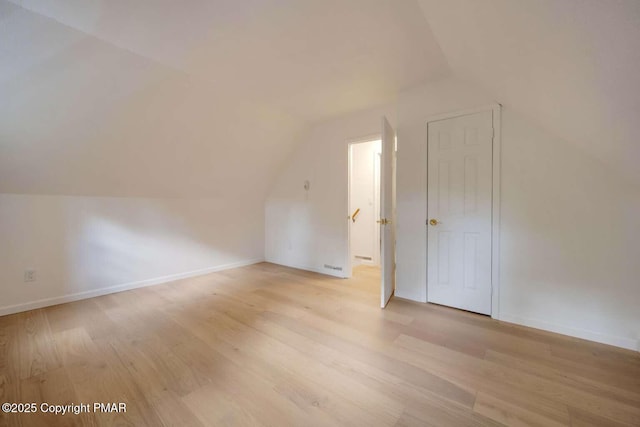 bonus room featuring lofted ceiling and light hardwood / wood-style flooring