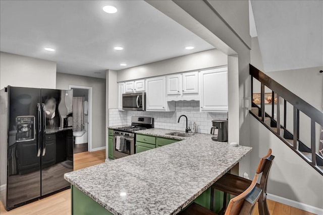 5266 Beechwood Rd, Blakeslee, PA 18610 - kitchen featuring a sink, a breakfast bar area, stainless steel appliances, white cabinetry, and a peninsula