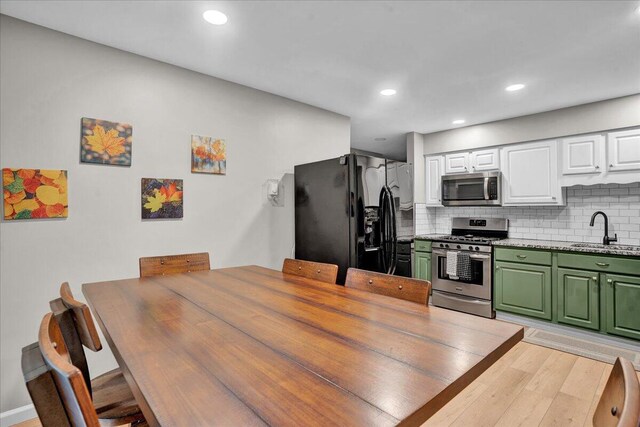 5266 Beechwood Rd, Blakeslee, PA 18610 - kitchen with backsplash, appliances with stainless steel finishes, a sink, green cabinets, and white cabinetry