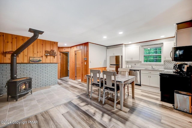 dining room featuring light hardwood / wood-style floors and a wood stove