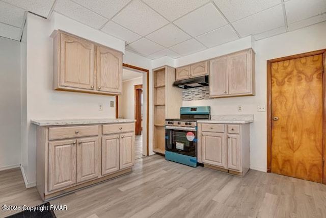 kitchen featuring stainless steel range oven, light countertops, light brown cabinetry, and under cabinet range hood