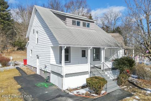 view of front of home with covered porch, aphalt driveway, and a shingled roof