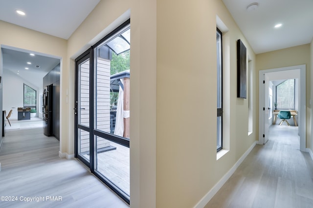 hallway featuring recessed lighting, baseboards, and light wood finished floors