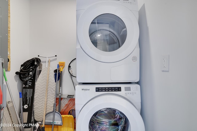 washroom featuring stacked washer / dryer and laundry area