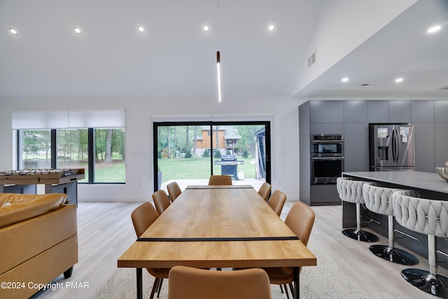 dining room with a healthy amount of sunlight, light wood finished floors, and visible vents