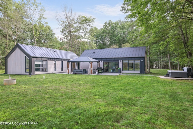 back of house featuring metal roof, central air condition unit, a gazebo, a yard, and a standing seam roof