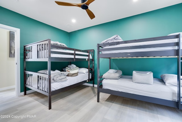 bedroom featuring ceiling fan, baseboards, and wood finished floors