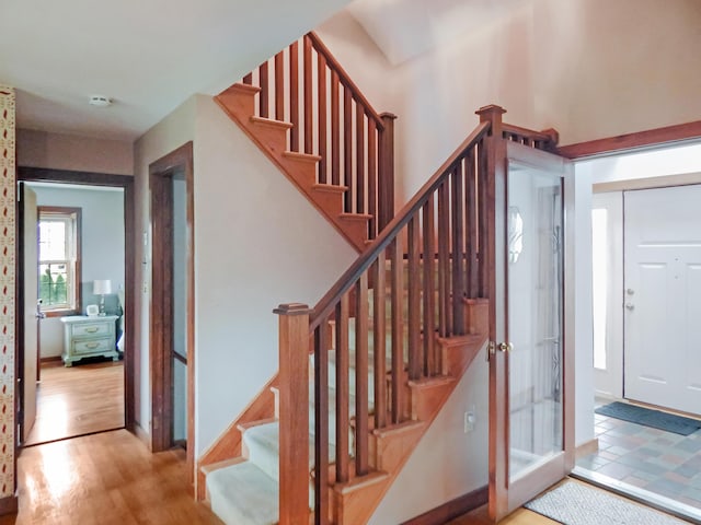 staircase featuring baseboards and wood finished floors