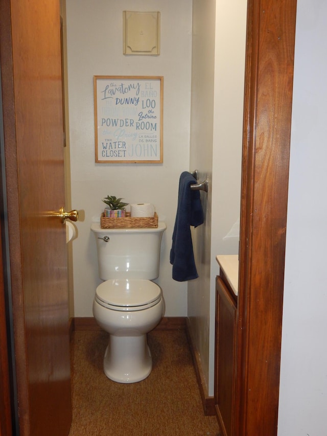 bathroom featuring baseboards, toilet, and vanity