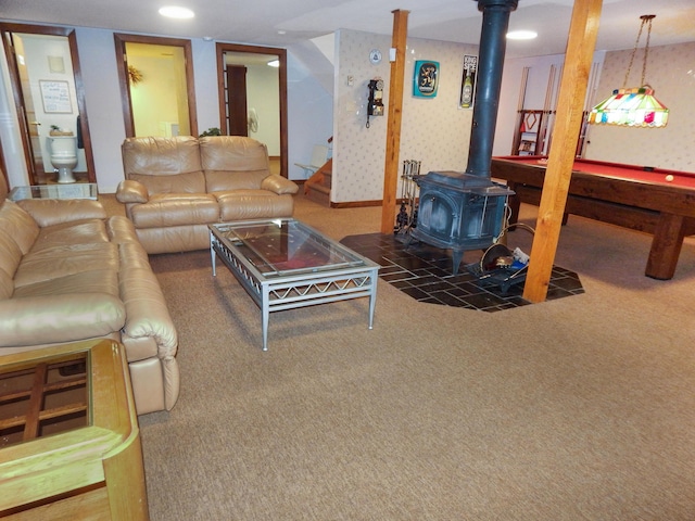 carpeted living area featuring a wood stove and wallpapered walls
