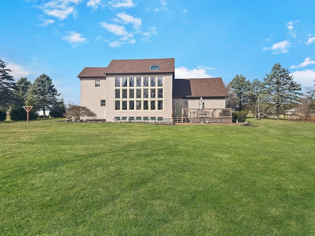 back of property with a lawn and a deck