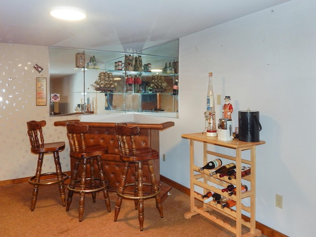 bar featuring a bar, carpet, and baseboards