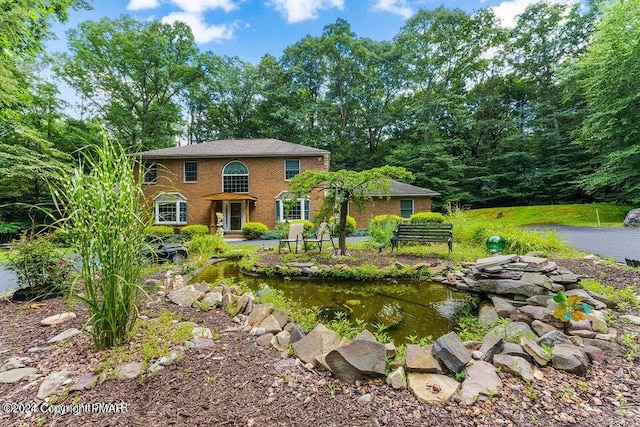 exterior space featuring a garden pond and brick siding