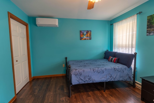 bedroom featuring ceiling fan, a wall mounted AC, wood finished floors, and baseboards