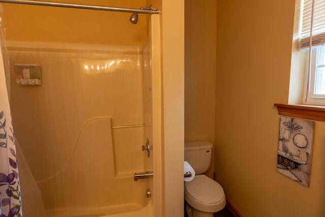 bathroom featuring toilet and shower / tub combo with curtain