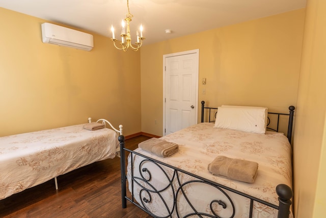 bedroom with dark wood-style floors, a wall unit AC, baseboards, and an inviting chandelier