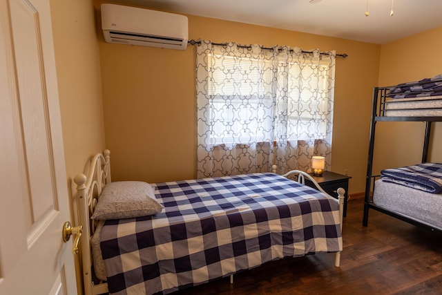 bedroom with a wall unit AC and wood finished floors